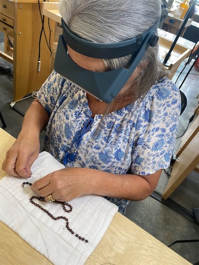 Student using a magnifying visor at the jewelry workbench