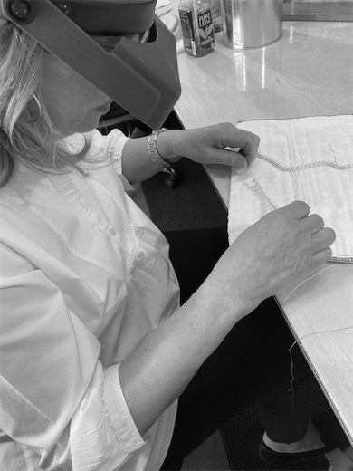 Student planning a jewelry design on gridded paper