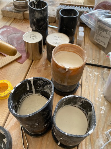 Jewelry casting containers and supplies on a workbench